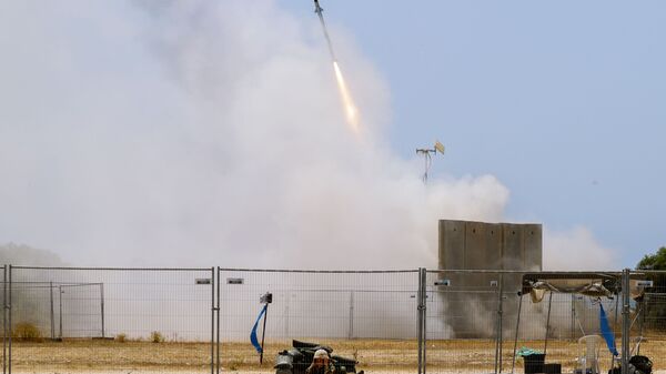 Soldado israelense se protege enquanto míssil do sistema antiaéreo Cúpula de Ferro é disparado para interceptar foguete lançado de Gaza - Sputnik Brasil