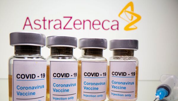 Frascos com adesivo dizendo COVID-19, vacina contra o coronavírus e uma seringa médica são vistos na frente de um logotipo da AstraZeneca - Sputnik Brasil