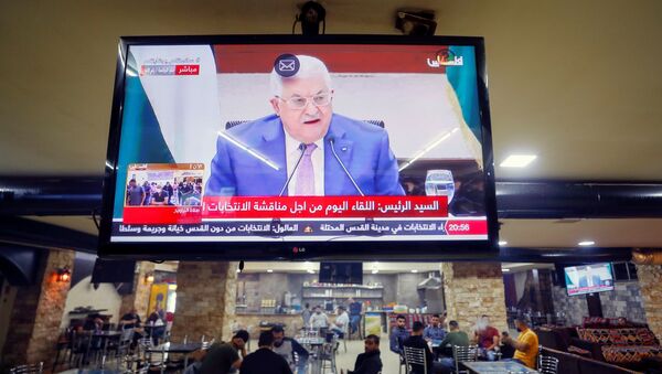 Uma tela exibindo uma transmissão ao vivo do discurso do presidente palestino Mahmoud Abbas durante reunião para discutir as próximas eleições em Ramallah, na Cisjordânia, em 29 de abril de 2021 - Sputnik Brasil