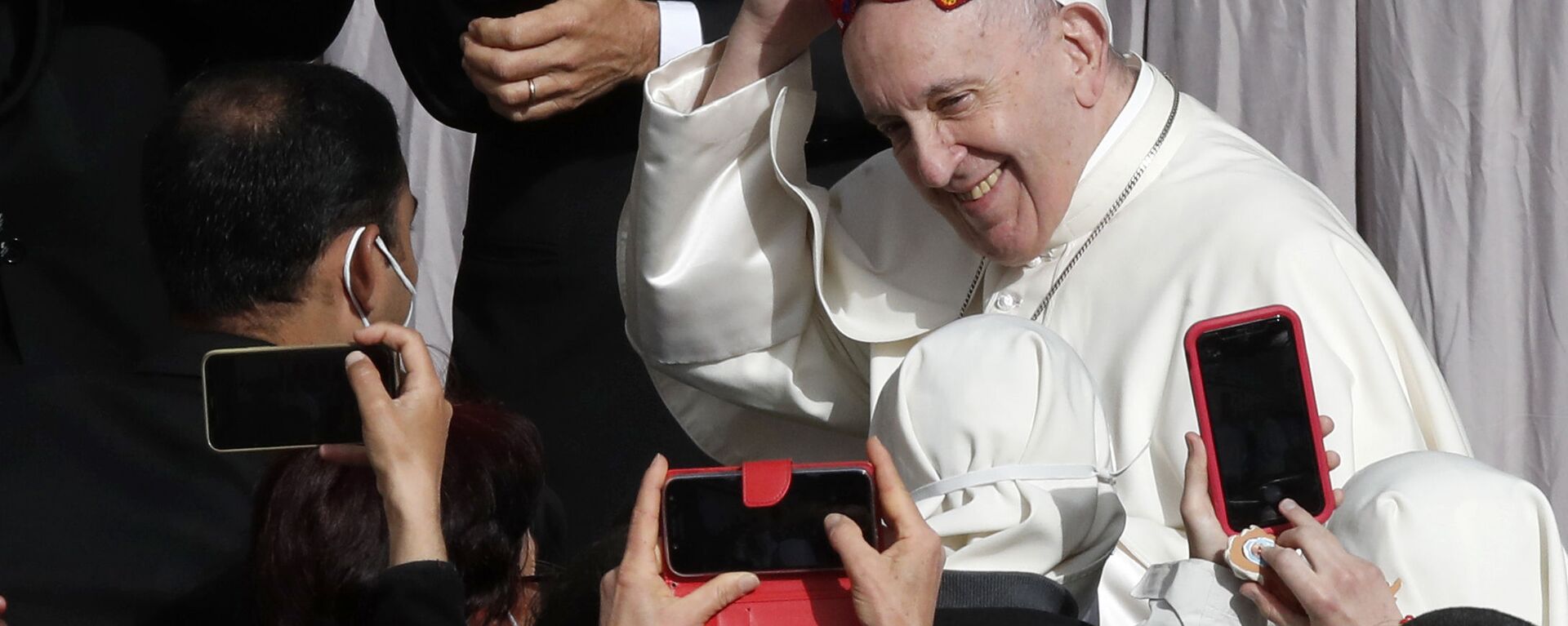 Papa Francisco sorrindo após uma das pessoas ter lhe colocado um chapéu durante a audiência  semanal do Papa no Vaticano, 12 de maio de 2021 - Sputnik Brasil, 1920, 21.04.2025