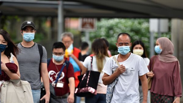 Pessoas usando máscaras de proteção atravessam uma estrada em Cingapura, 14 de maio de 2021 - Sputnik Brasil