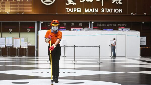 A woman wears a face shield and a face mask while cleaning the lobby of Taipei main station amid a surge of coronavirus disease (COVID-19) infections in Taipei, Taiwan, May 18, 2021. - Sputnik Brasil