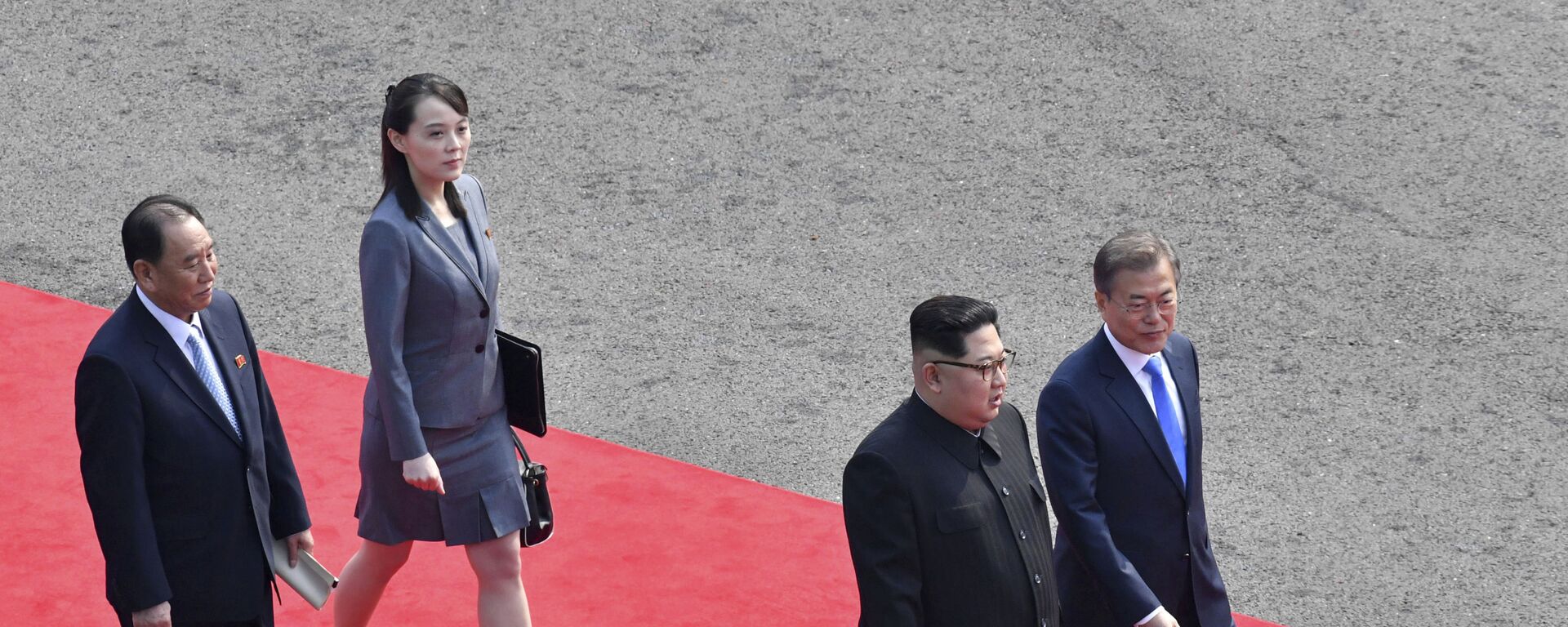 O líder norte-coreano, Kim Jong-un (de óculos), caminha com o presidente sul-coreano, Moon Jae-in, seguidos pela irmã de Kim Kim Yo-jong, para fazer uma reunião na aldeia fronteiriça de Panmunjom, na Zona Desmilitarizada da Coreia, 27 de abril de 2018. - Sputnik Brasil, 1920, 04.04.2022