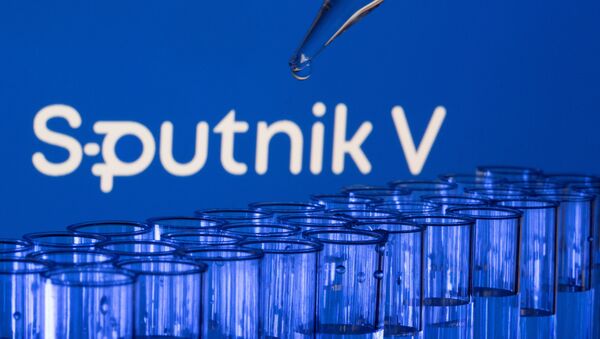 Tubos de ensaio são vistos à frente de um logotipo do Sputnik V, em foto de 21 de maio de 2021 - Sputnik Brasil