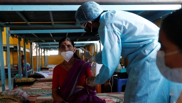 Um médico inspeciona um paciente com COVID-19 em uma sala de aula transformada em instalação de cuidados contra a pandemia nos arredores de Mumbai, na Índia, em 24 de maio de 2021 - Sputnik Brasil