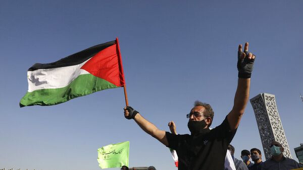 Manifestante segura bandeira palestina enquanto faz sinal da vitória em Teerã, no Irã - Sputnik Brasil