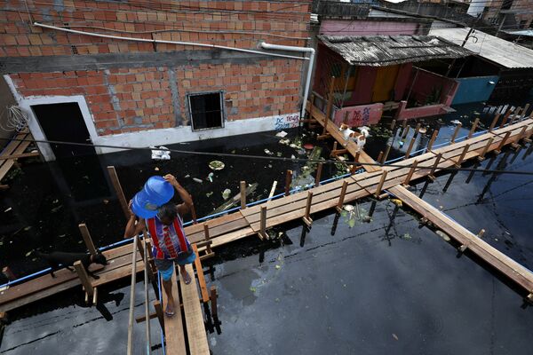 Homem transporta água potável por rua inundada após transbordamento do rio Negro, Manaus, Amazonas, Brasil, 28 de maio de 2021 - Sputnik Brasil