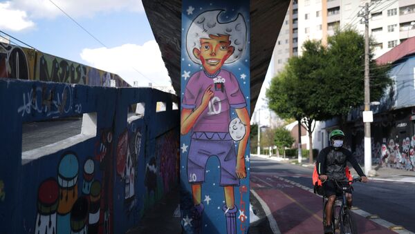 A man rides a bike near a graffiti depicting a soccer player in Sao Paulo, Brazil June 1, 2021. - Sputnik Brasil