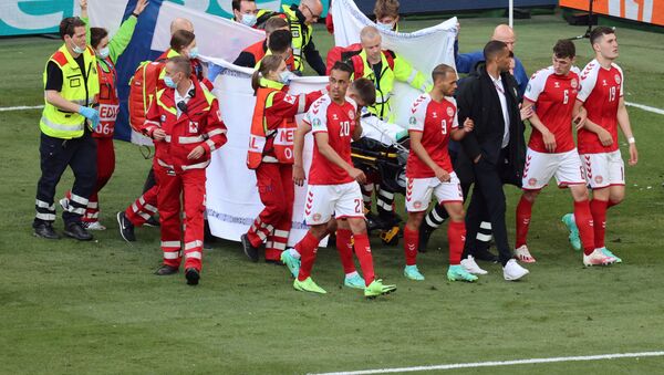 Jogadores da Dinamarca se reúnem enquanto paramédicos assistem o meio-campista Christian Eriksen (fora da foto) durante a partida de futebol do Grupo B do UEFA EURO 2020 entre a Dinamarca e a Finlândia, no Estádio Parken em Copenhague, Dinamarca, 12 de junho de 2021 - Sputnik Brasil