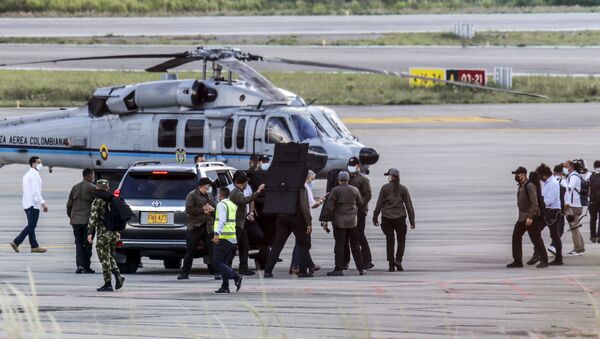Presidente da Colômbia Iván Duque rodeado por guarda-costas perto do helicóptero presidencial que foi alvo de ataque no nordeste do país - Sputnik Brasil