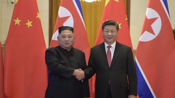 In this Tuesday, Jan. 8, 2019, photo released by China's Xinhua News Agency, North Korean leader Kim Jong Un, left, and Chinese President Xi Jinping shake hands as they pose for a photo before talks at the Great Hall of the People in Beijing - Sputnik Brasil