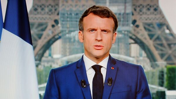 Presidente francês Emmanuel Macron é visto em uma tela de televisão durante discurso transmitido à nação em Paris em 12 de julho de 2021 - Sputnik Brasil