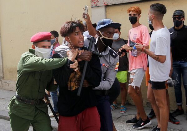 Policiais imobilizam uma pessoa durante os protestos contra e em apoio ao governo, em Havana, no domingo (11) - Sputnik Brasil
