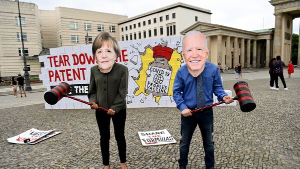 Manifestantes disfarçados da chanceler alemã Angela Merkel e presidente americano Joe Biden se preparam para destruir o muro de patentes em frente do Portão de Brandemburgo, Berlim, Alemanha, 14 de julho de 2021 - Sputnik Brasil