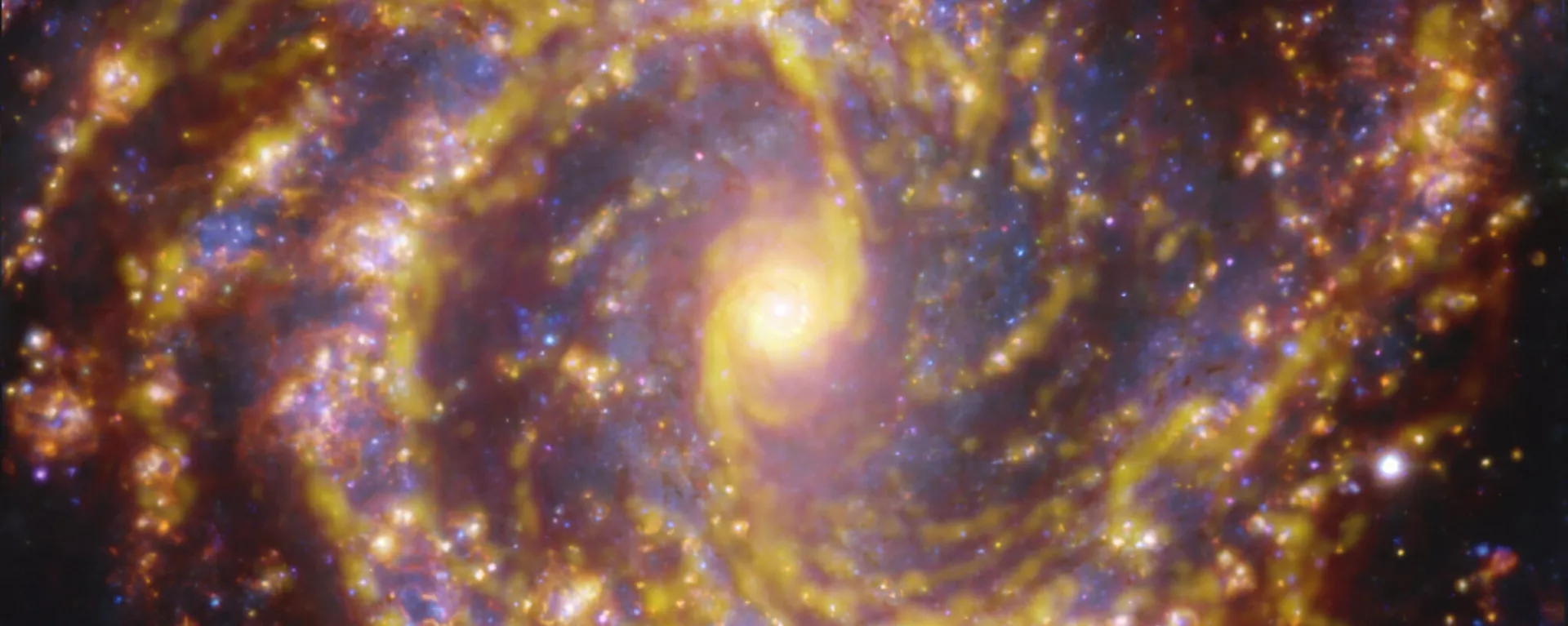 Galáxia NGC 4303 próxima à Via Láctea. NGC 4303 é uma galáxia espiral, com uma barra de estrelas e gás em seu centro, localizada a aproximadamente 55 milhões de anos-luz da Terra, na constelação Virgo. A imagem é uma combinação de observações realizadas em diferentes comprimentos de onda de luz para mapear populações estelares e gás. As observações do telescópio ALMA são representadas em tons marrom-alaranjados e destacam as nuvens de gás molecular frio que fornecem a matéria-prima a partir da qual as estrelas se formam. Os dados do espetrógrafo MUSE aparecem principalmente em dourado e azul. Os brilhantes dourados mapeiam nuvens quentes, principalmente de hidrogênio ionizado, oxigênio e gás sulfúrico, marcando a presença de estrelas recém-nascidas, enquanto as regiões azuis revelam a distribuição de estrelas ligeiramente mais velhas - Sputnik Brasil, 1920, 22.07.2025