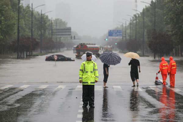 Policial em frente de rua inundada em Zhengzhou, província de Henan, China, 20 de julho de 2021 - Sputnik Brasil
