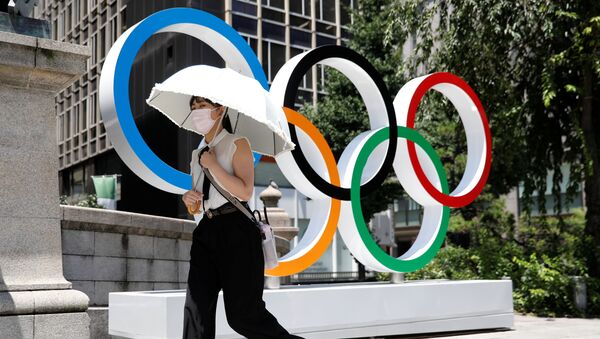 Mulher passa pelo símbolo dos Jogos Olímpicos em Tóquio, antes do começo da competição, 21 de julho de 2021 - Sputnik Brasil
