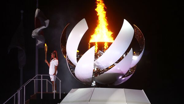 Naomi Osaka do Japão segura a tocha olímpica após acender a pira olímpica na cerimônia de abertura - Sputnik Brasil