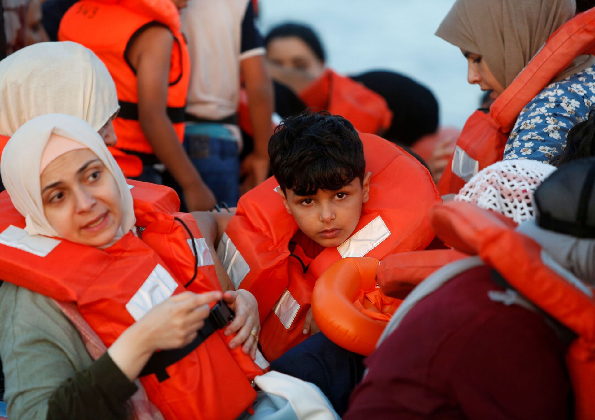 Migrantes aguardam em um barco para serem salvos por navio de regate de ONG alemã em águas internacionais no mar Mediterrâneo, 30 de julho de 2021 - Sputnik Brasil, 1920, 26.12.2021