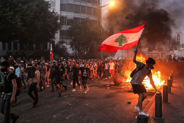 Manifestante segura bandeira libanesa em meio a confrontos com forças de segurança em Beirute, no Líbano, 4 de agosto de 2021 - Sputnik Brasil