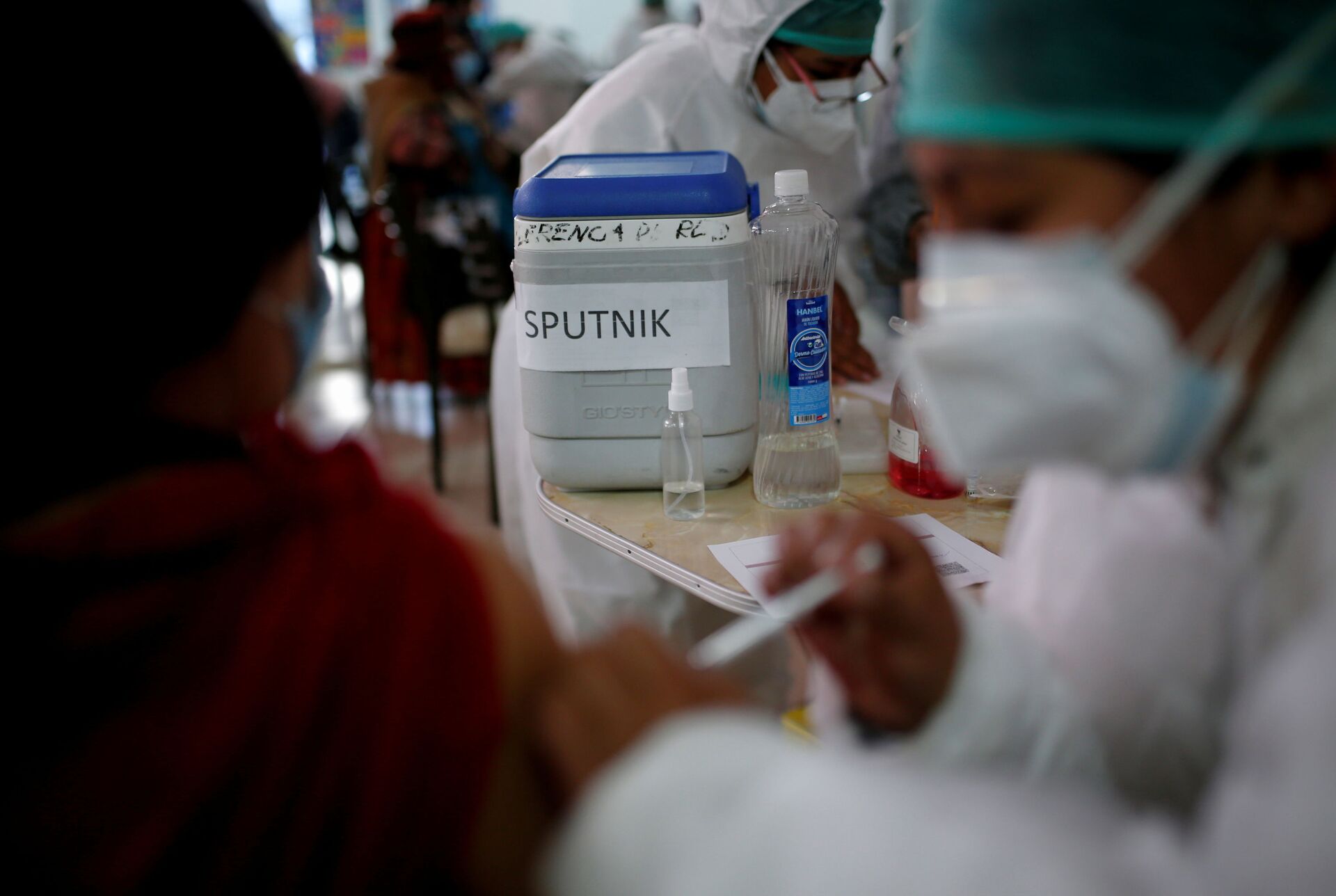 Pessoa é imunizada com vacina russa Sputnik V contra a doença do coronavírus (COVID-19) em uma estação de teleféricos Mi Teleferico transformada em centro de vacinação, em El Alto, Bolívia, 25 de julho de 2021 - Sputnik Brasil, 1920, 26.12.2021