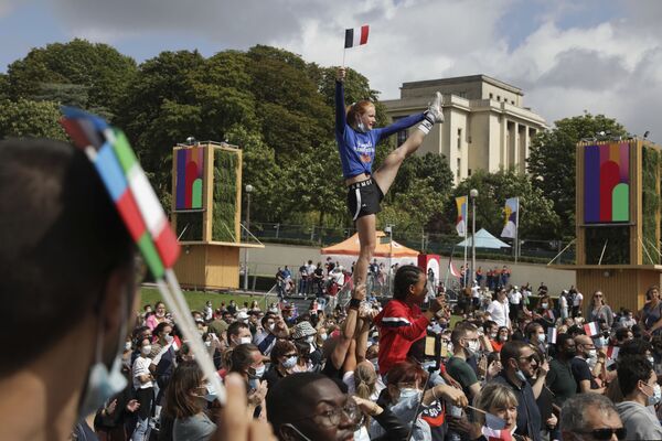 Uma mulher segura a bandeira francesa enquanto mostra suas acrobacias na zona de fãs dos Jogos Olímpicos na capital francesa, Paris, 8 de agosto de 2021 - Sputnik Brasil