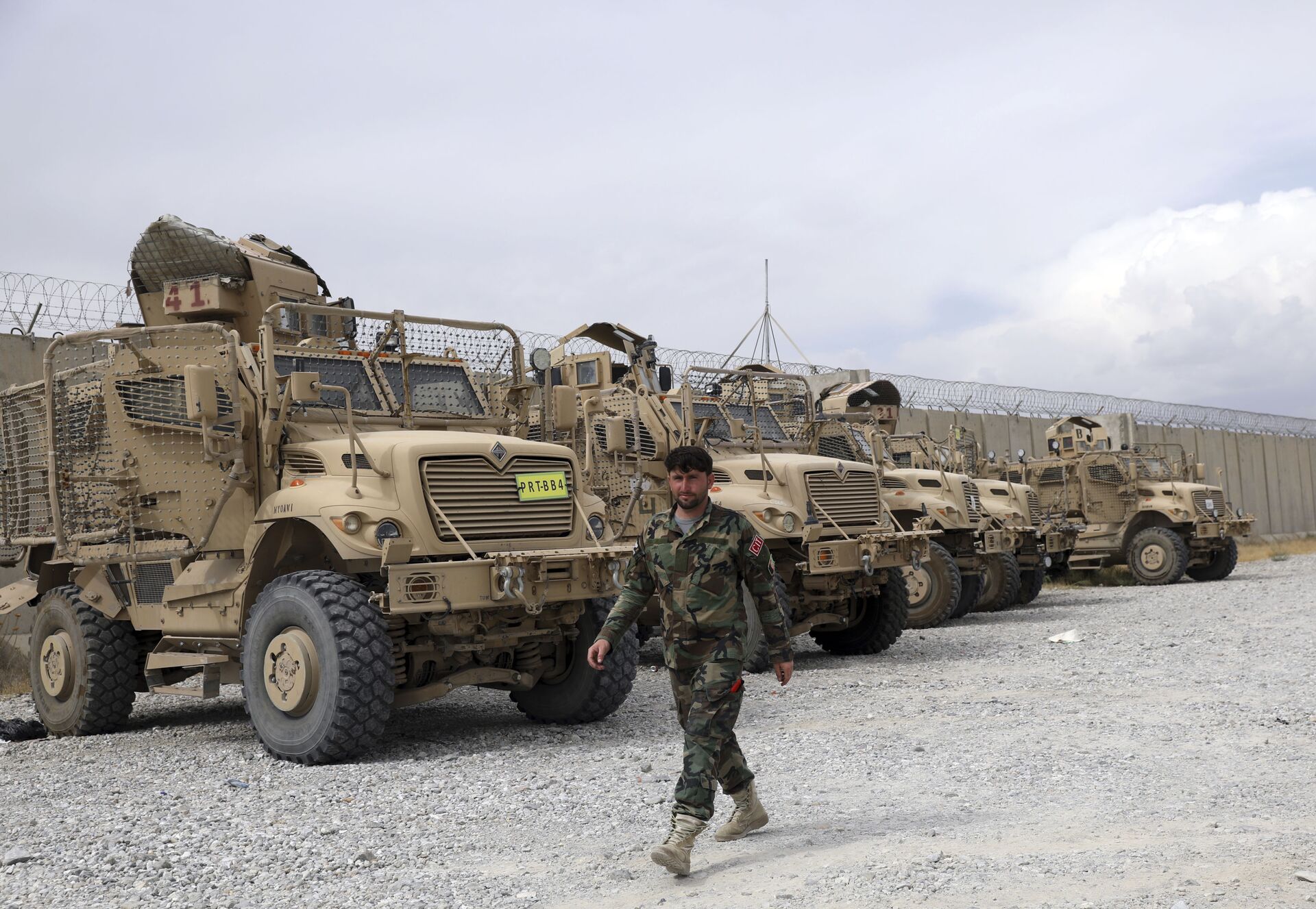 Soldado afegão passa por veículos MRAP (protegidos contra emboscadas e resistentes a minas) que os EUA deixaram na base aérea de Bagram, Afeganistão, 5 de julho de 2021 - Sputnik Brasil, 1920, 05.07.2022