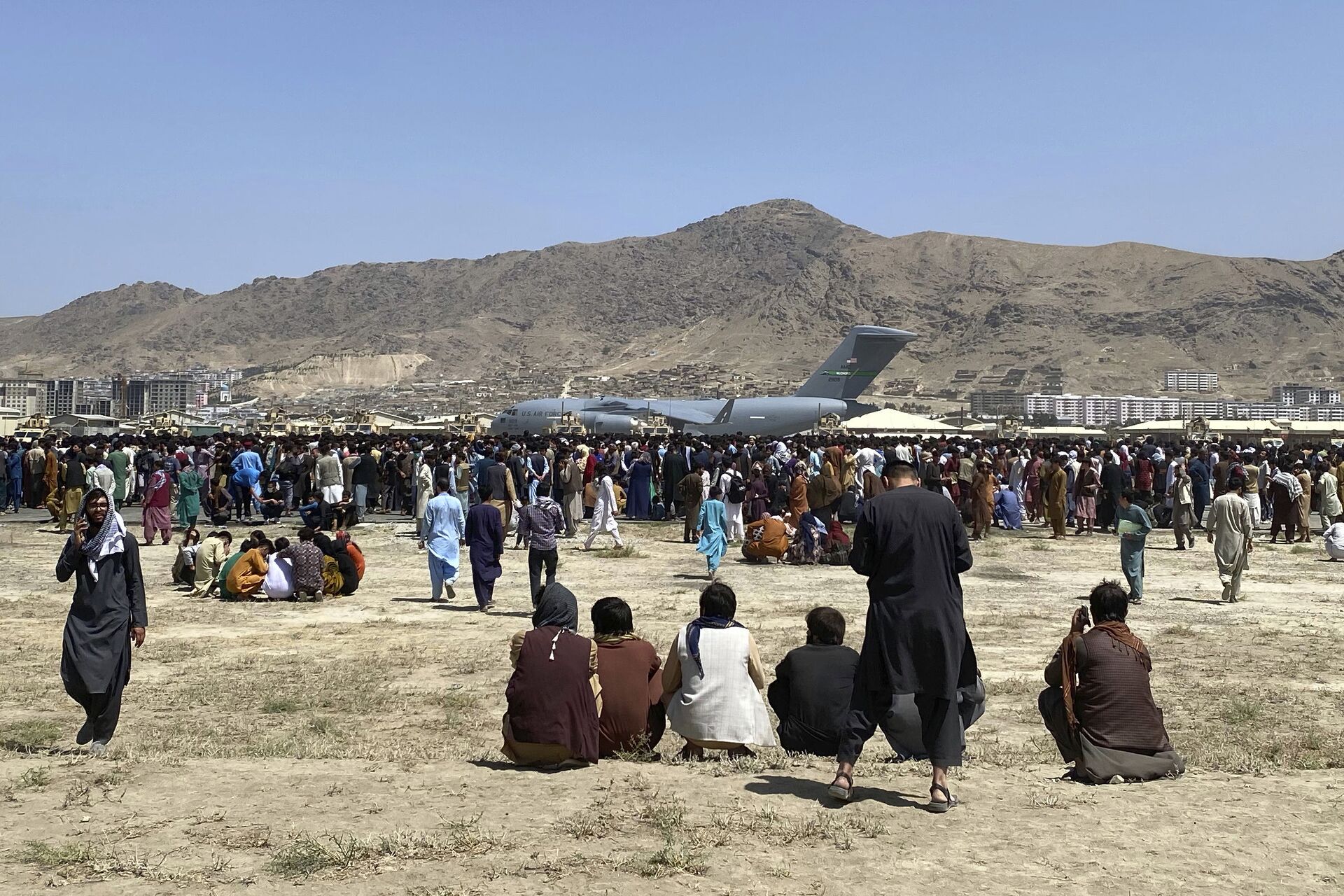 Centenas de pessoas se reúnem perto de um avião de transporte C-17 da Força Aérea dos EUA em um perímetro no aeroporto internacional de Cabul, Afeganistão, 16 de agosto de 2021 - Sputnik Brasil, 1920, 13.11.2021