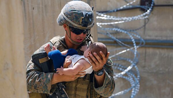 Soldado dos EUA conforta um bebê durante evacuação no Aeroporto Internacional Hamid Karzai, Afeganistão, 21 de agosto de 2021 - Sputnik Brasil