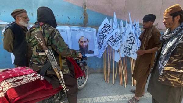Membros do Talibã (organização terrorista proibida na Rússia e em vários outros países) observam foto de seu líder Mullah Haibatullah Akhundzada, em Cabul, Afeganistão, 25 de agosto de 2021 - Sputnik Brasil