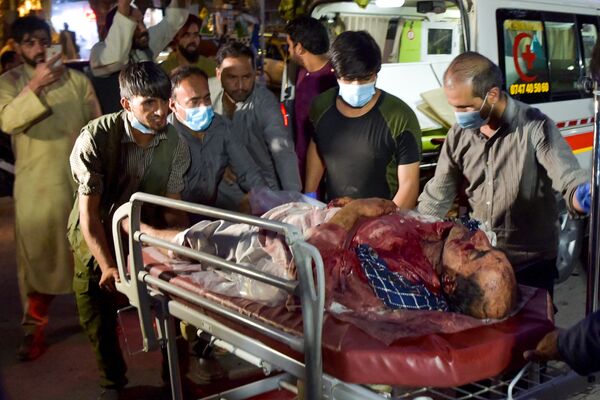 Equipe médica e voluntários levam um homem ferido para tratamento após fortes explosões em Cabul, Afeganistão, 26 de agosto de 2021 - Sputnik Brasil