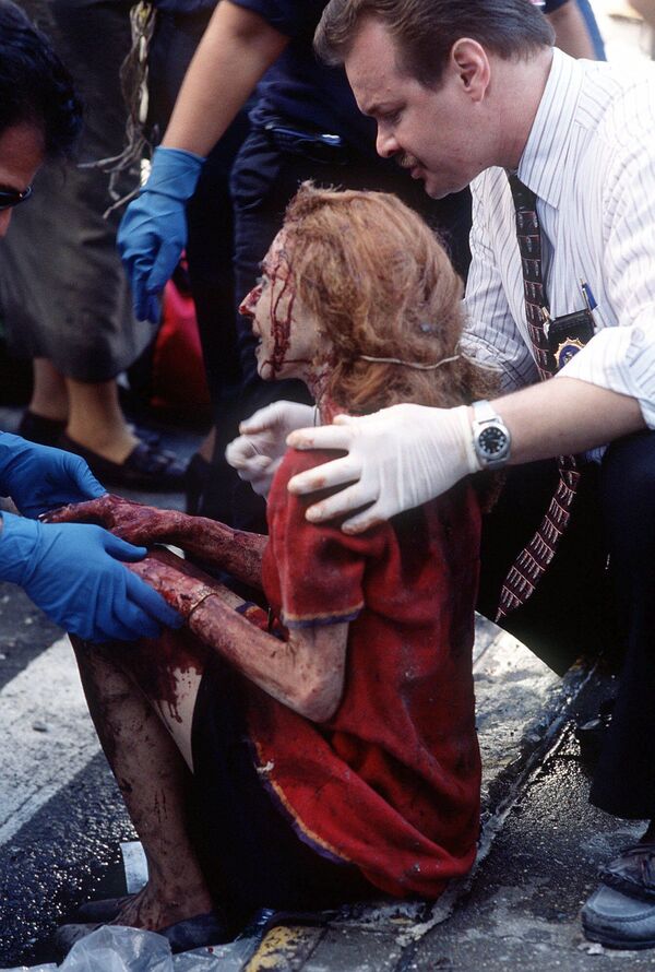 Trabalhadores de emergência ajudam uma mulher depois que ela ficou ferida no ataque terrorista ao World Trade Center em Nova York, 11 de setembro de 2001. - Sputnik Brasil