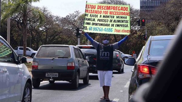 Homem segura cartaz pedindo emprego pelo trânsito do Distrito Federal. Segundo dados, o DF foi a unidade da federação que mais empobreceu entre o primeiro trimestre de 2019 e janeiro de 2021. 20 de agosto de 2021 - Sputnik Brasil