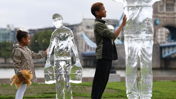 Crianças posam perto de esculturas de gelo representando pessoas coletando água da organização de caridade Water Aid, simbolizando a fragilidade da água e a ameaça das mudanças climáticas, Londres, 15 de setembro de 2021 - Sputnik Brasil