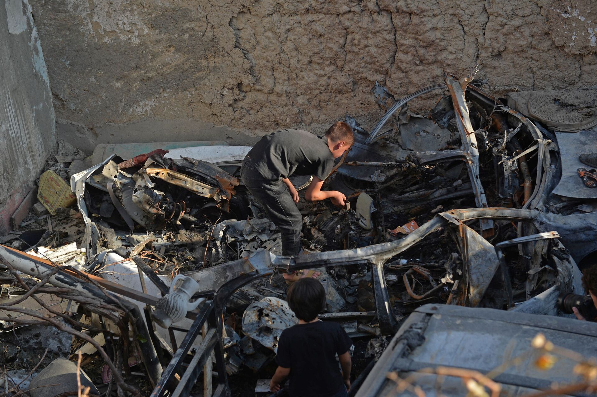Parente de Zemari Ahmadi inspeciona os destroços do veículo atingido por ataque de drone dos EUA em Cabul, em 18 de setembro de 2021 - Sputnik Brasil, 1920, 09.11.2021