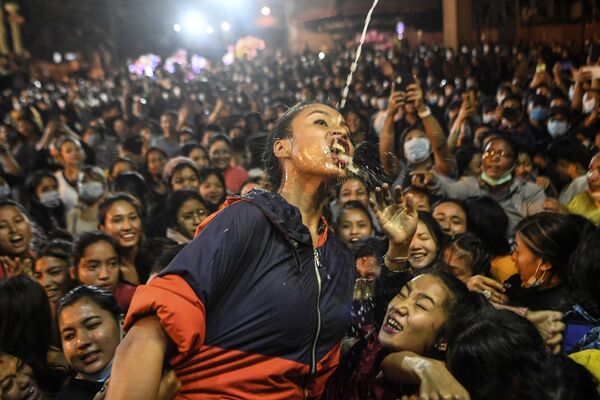 Mulher bebendo vinho que jorra da estátua de Shwet Bhairav (deus protetor) durante o festival hindu Indra Jatra em Kathmandu, no Nepal, em 21 de setembro de 2021. - Sputnik Brasil