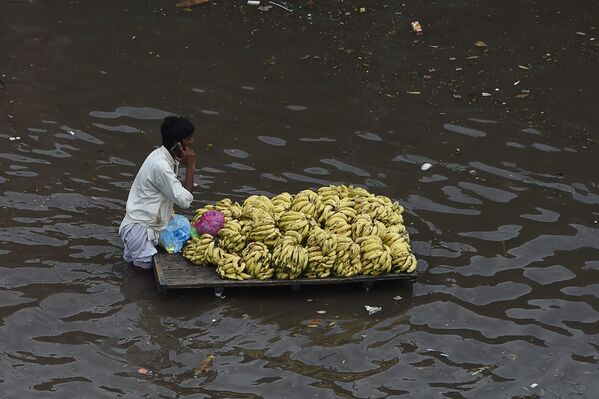 Vendedor de frutas empurra sua mercadoria através de submersa por enchente em Lahore, no Paquistão, em 21 de setembro de 2021.
 - Sputnik Brasil