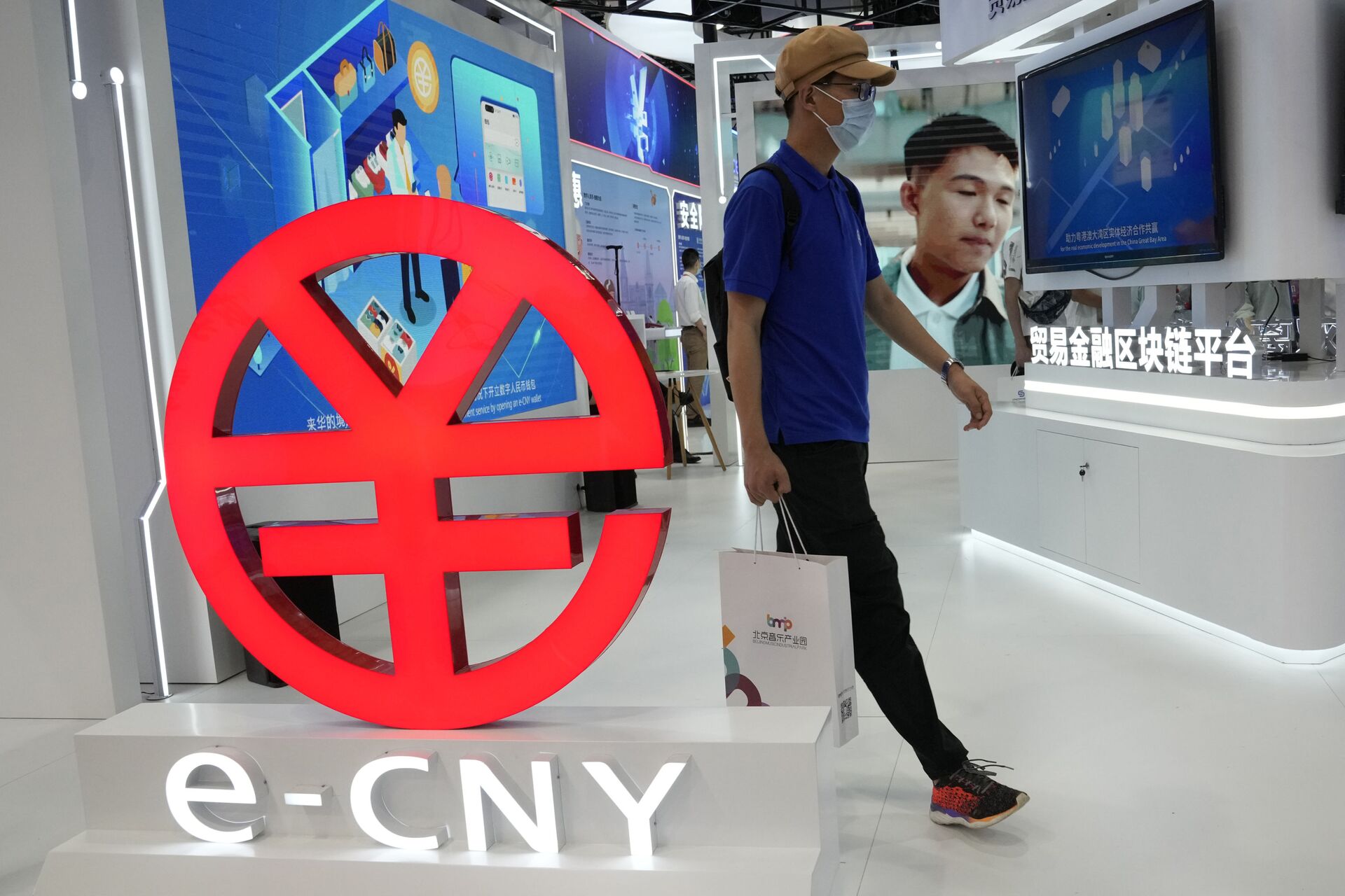 Visitante passa pelo logo do e-CNY, versão digital do yuan chinês. Pequim, China, 5 de setembro de 2021 - Sputnik Brasil, 1920, 09.11.2021