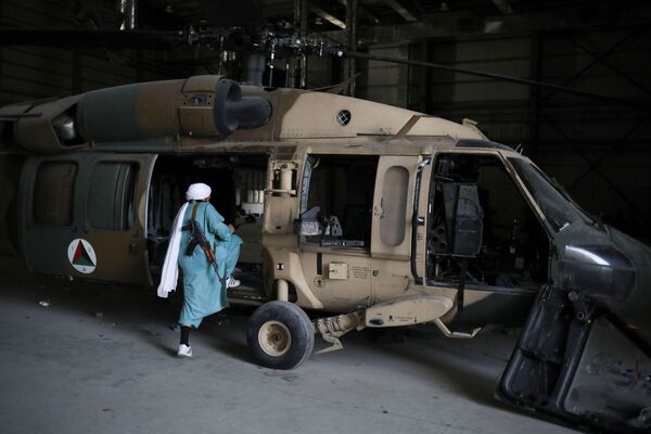 Soldado do Talibã entra em um helicóptero na base aérea de Bagram, na província de Parwan, Afeganistão, 23 de setembro de 2021. - Sputnik Brasil