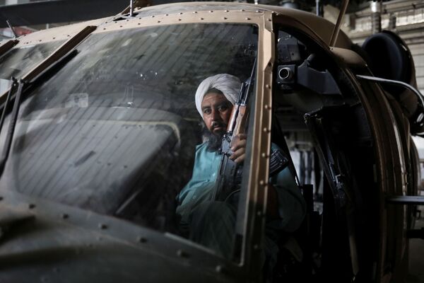 Soldado talibã armado e ex-prisioneiro em um helicóptero militar na base aérea de Bagram, na província de Parwan, Afeganistão, 23 de setembro de 2021. - Sputnik Brasil