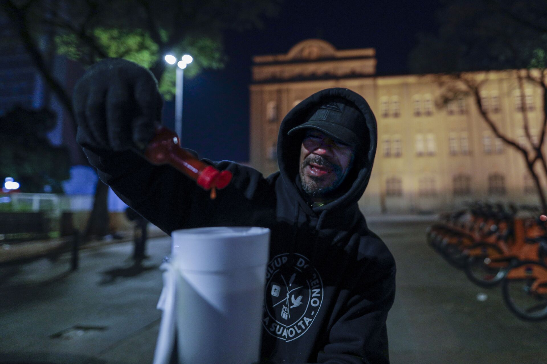 Sem-teto em rua de São Paulo coloca molho de pimenta na sopa durante uma noite fria em São Paulo, 29 de julho de 2021 - Sputnik Brasil, 1920, 09.11.2021