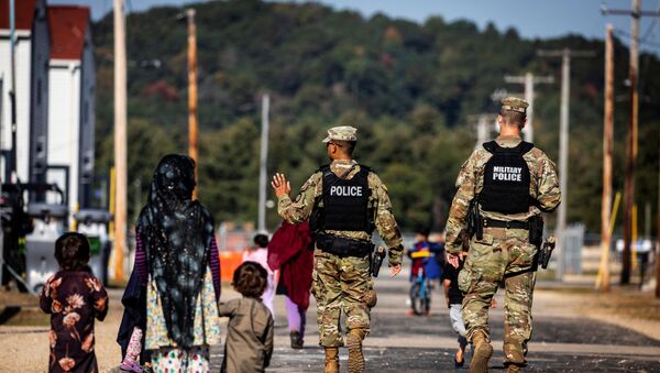 Soldados da Polícia Militar dos EUA e refugiados afegãos na base militar norte-americana de Fort McCoy, Wisconsin, EUA, 30 de setembro de 2021 - Sputnik Brasil