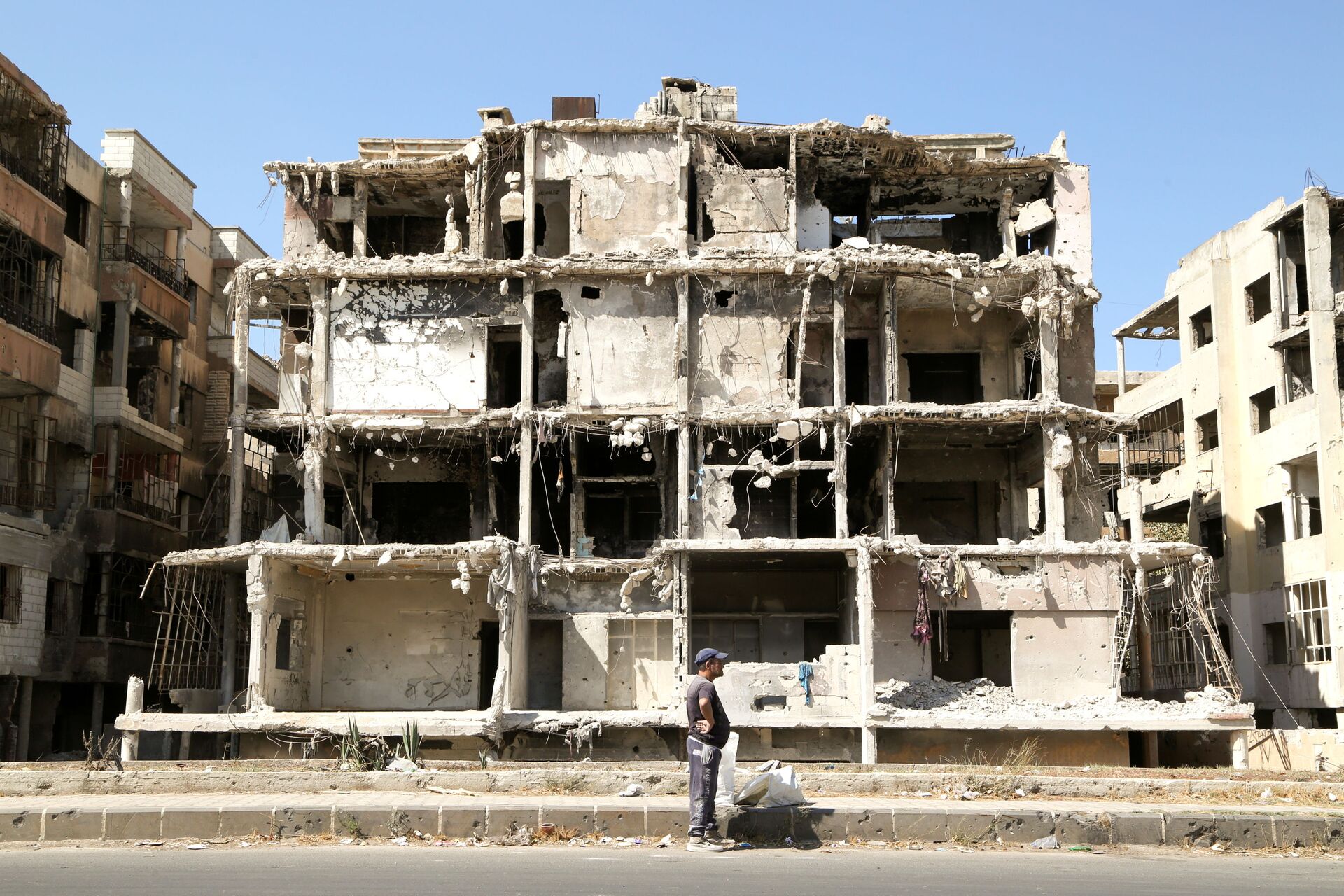Homem passa por prédio danificado em Homs, Síria, 3 de outubro de 2021 - Sputnik Brasil, 1920, 09.11.2021