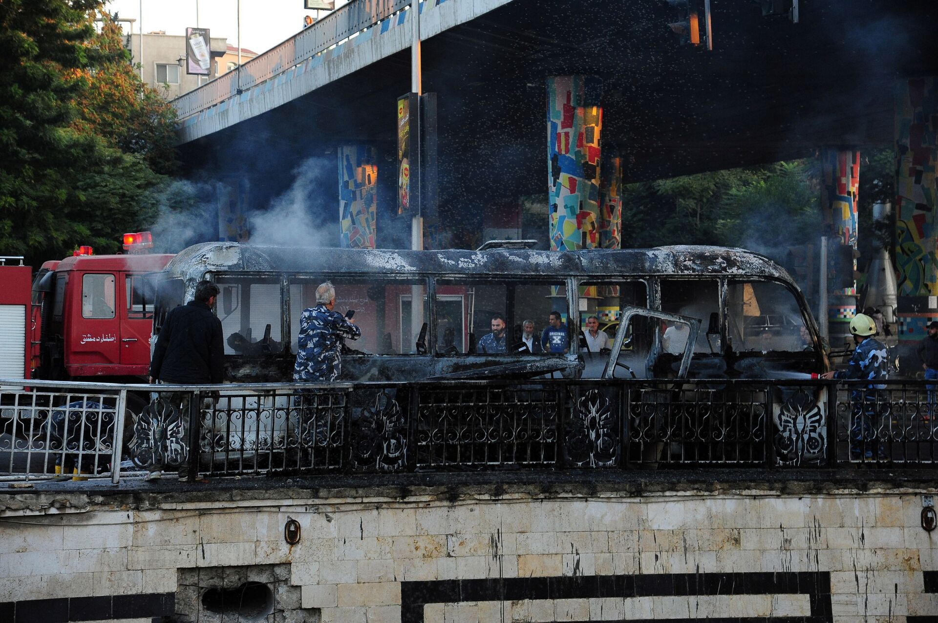 Bombeiros apagando fogo do ônibus atingido pelo ataque terrorista na manhã de quarta-feira, 20 de outubro, na capital da Síria, Damasco   - Sputnik Brasil, 1920, 09.11.2021