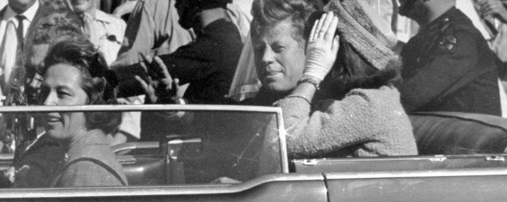 John F. Kennedy, presidente norte-americano (1961-1963), acena de seu carro em uma carreata aproximadamente um minuto antes de ser mortalmente baleado em Dallas, Texas, EUA, 22 de novembro de 1963 - Sputnik Brasil, 1920, 24.10.2021