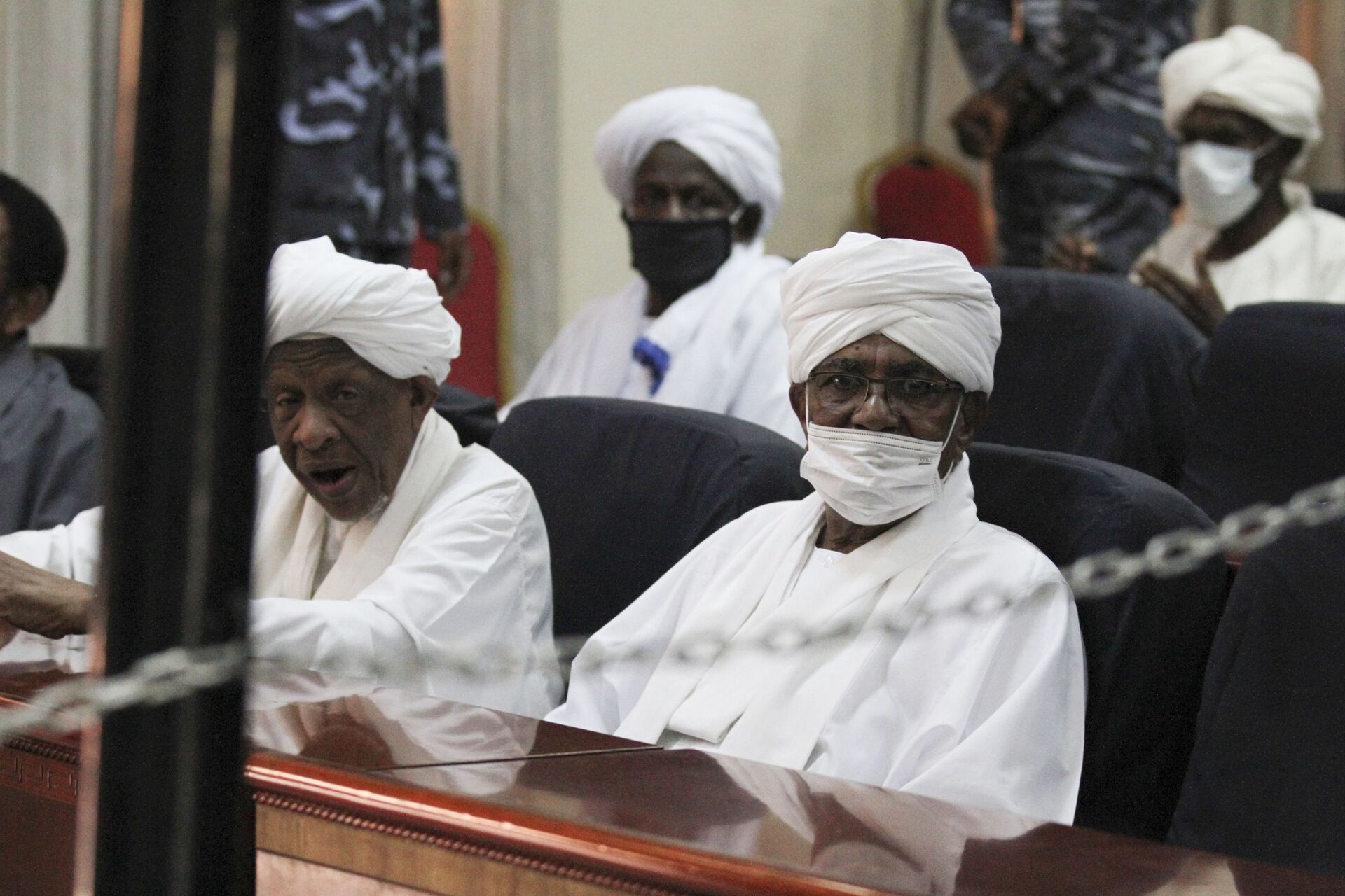 O presidente deposto do Sudão, Omar al-Bashir, à direita, está sentado durante seu julgamento em um tribunal em Cartum, Sudão, 24 de agosto de 2021 - Sputnik Brasil, 1920, 09.11.2021