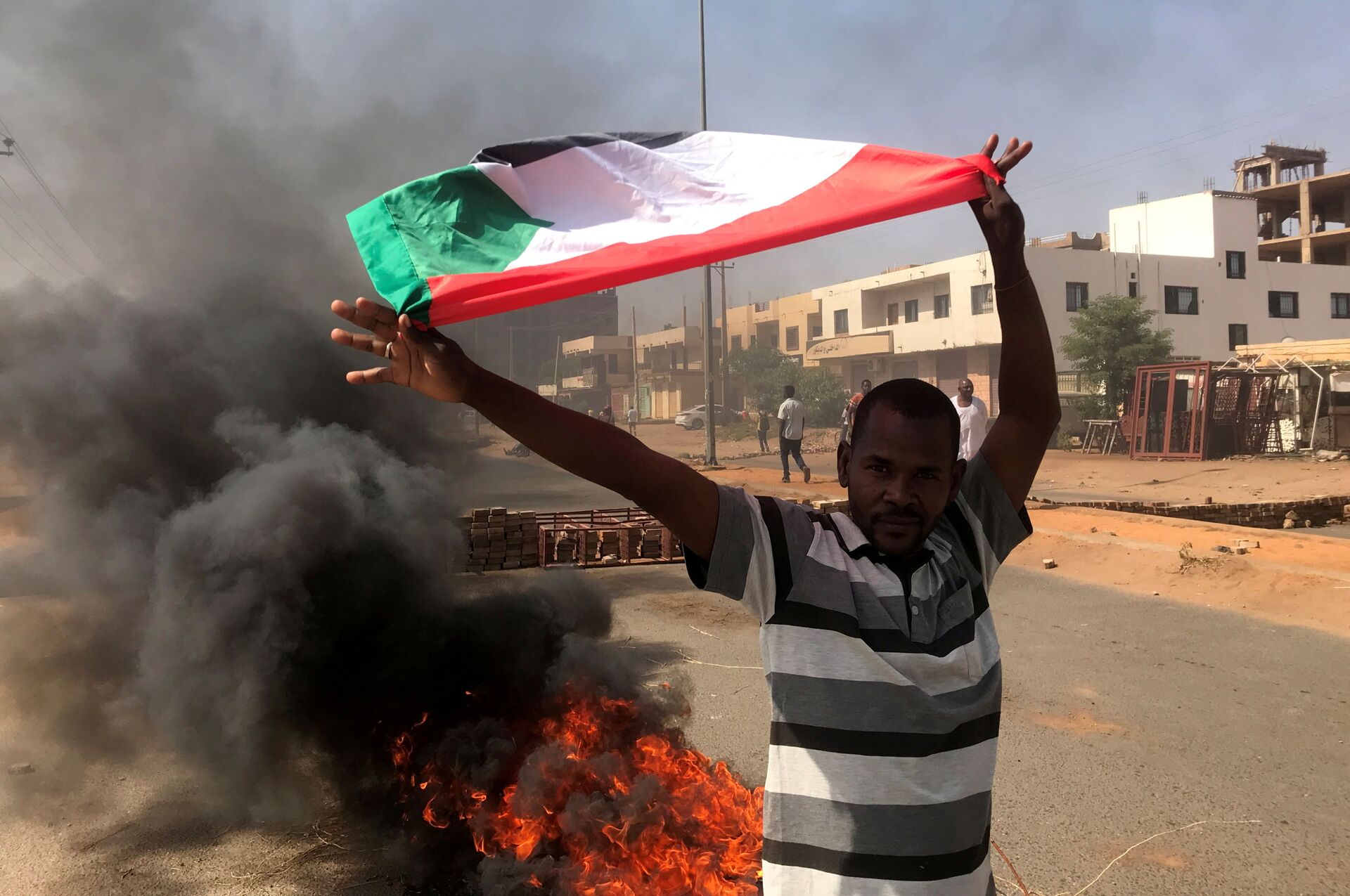 Um manifestante agita uma bandeira durante o que o ministério da informação chama de golpe militar em Cartum, Sudão, em 25 de outubro de 2021 - Sputnik Brasil, 1920, 09.11.2021