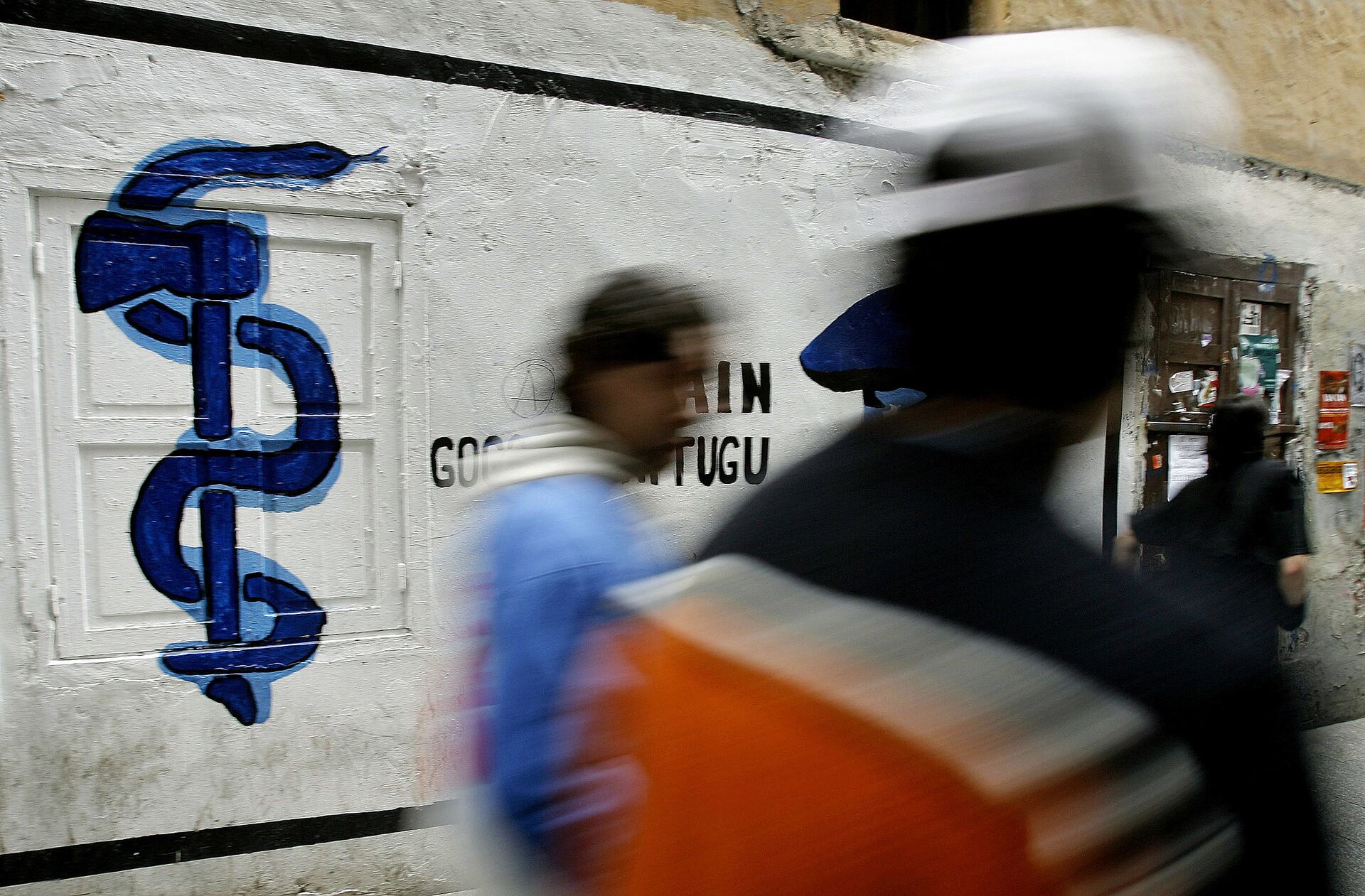 Pessoas passam por uma parede pintada com grafite com a logo do grupo separatista basco ETA em Hernani, norte da Espanha (foto de arquivo) - Sputnik Brasil, 1920, 09.11.2021