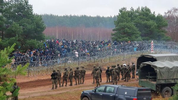 Militares poloneses guardam centenas de migrantes na fronteira entre a Polônia e a Belarus perto de Kuznica Bialostocka, Polônia - Sputnik Brasil