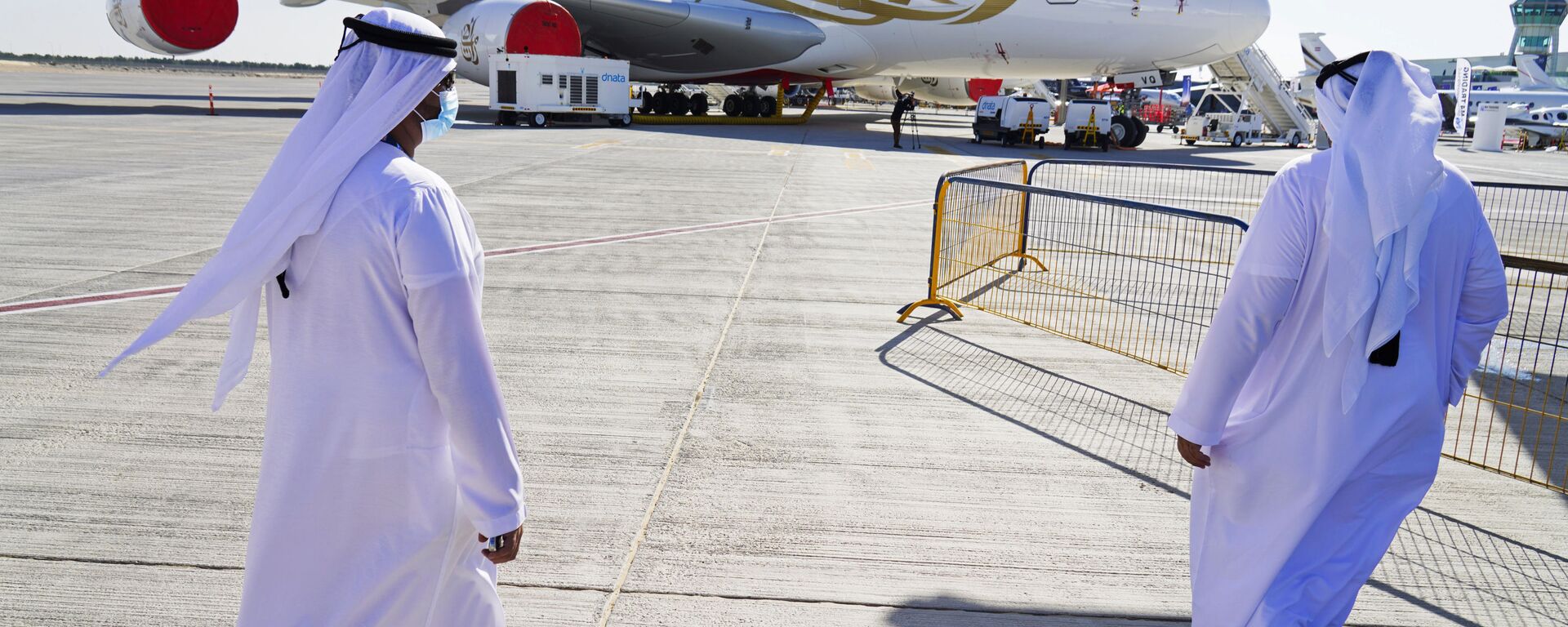 Dois emiradenses se aproximam de avião a jato Emirates Airbus A380 em exibição no Show Aéreo de Dubai, Emirados Árabes Unidos, 14 de novembro de 2021 - Sputnik Brasil, 1920, 07.03.2026